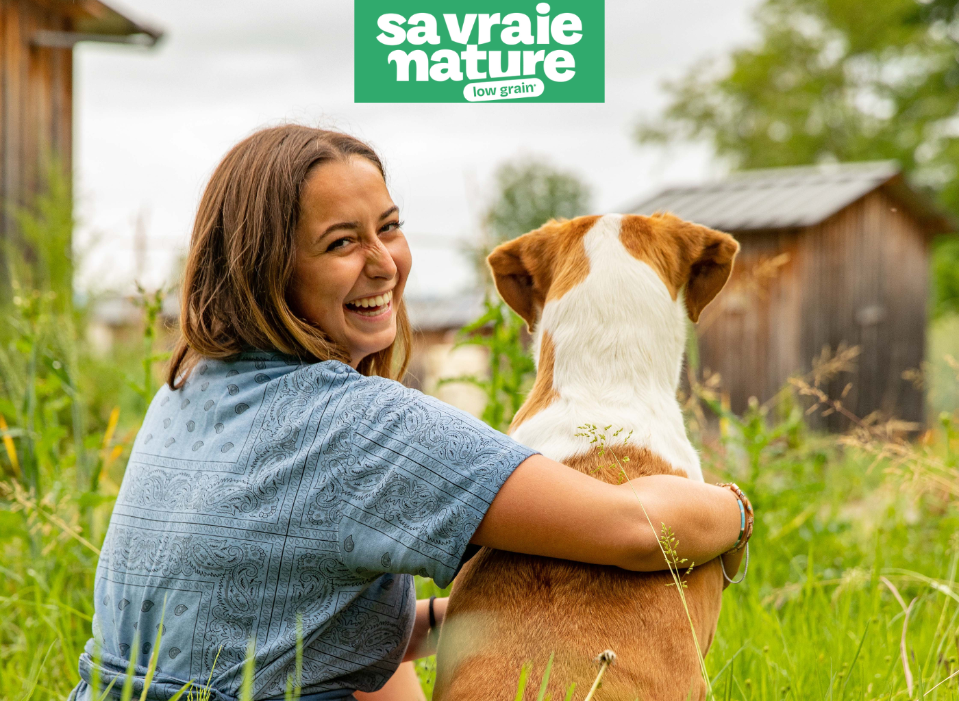 Une femme et son chien assis dans l'herbe